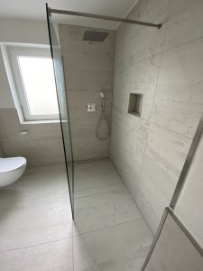 Badsanierung Augsburg Bad modern mit Glasdusche, Fliesen grauFliesenarbeit Großformat 60x120
